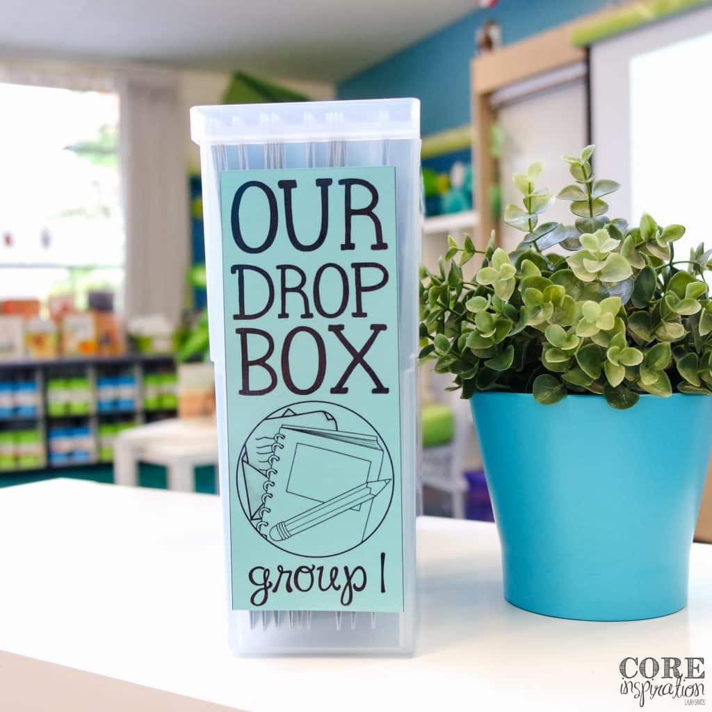 Core Inspiration Homework Drop Box sitting next to plant on top of white surface. 